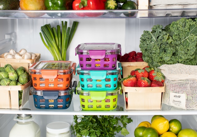 Fridge filled with fresh fruits and vegetables as well as meal prepped food in ello brand glass containers