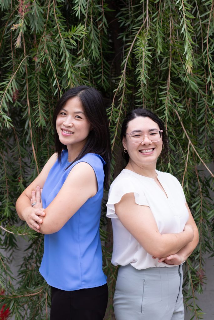 Two professional women standing back to back